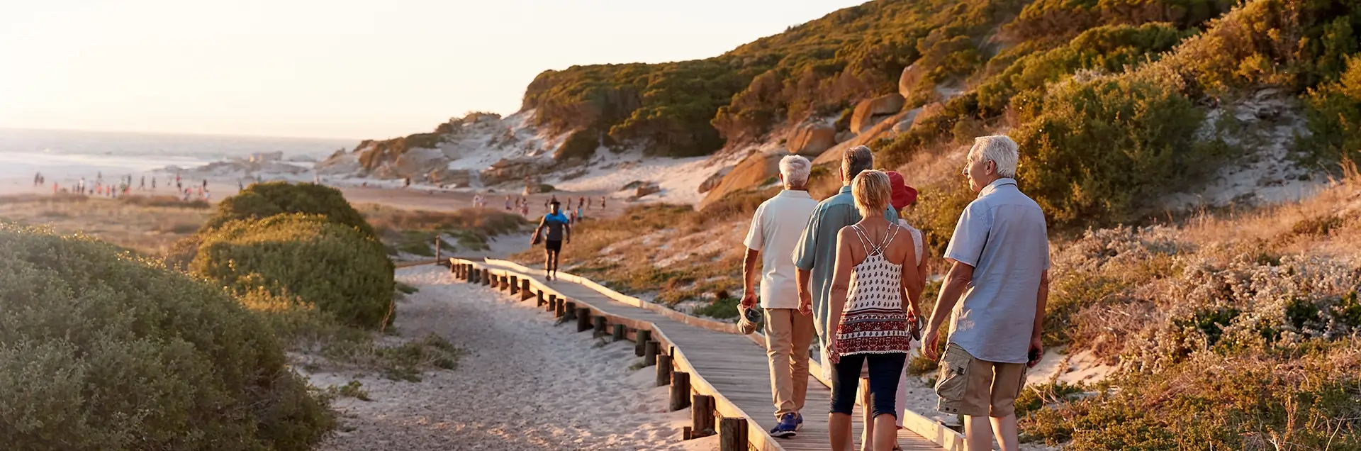 Gruppe von Menschen wandert am Strand entlang